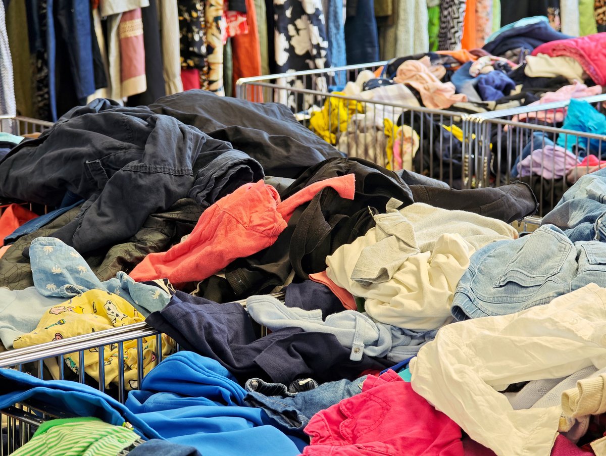 Colorful heaps of secondhand kids clothing in thrift bins