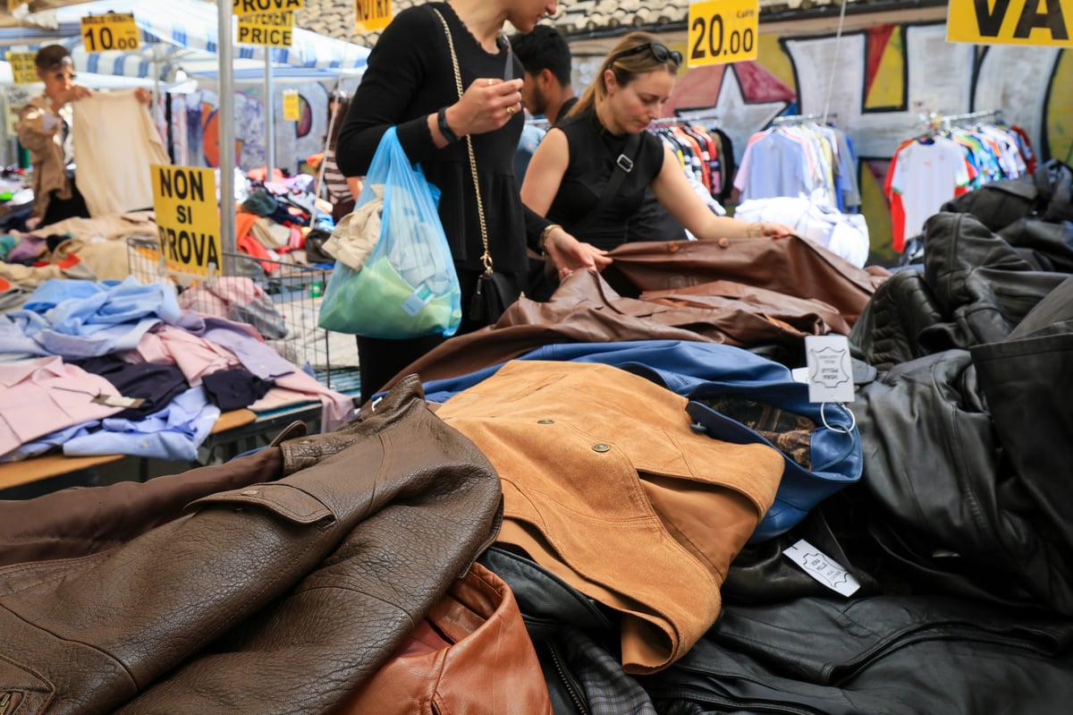 A vibrant street market stall selling secondhand leather jackets at Empire Buddies